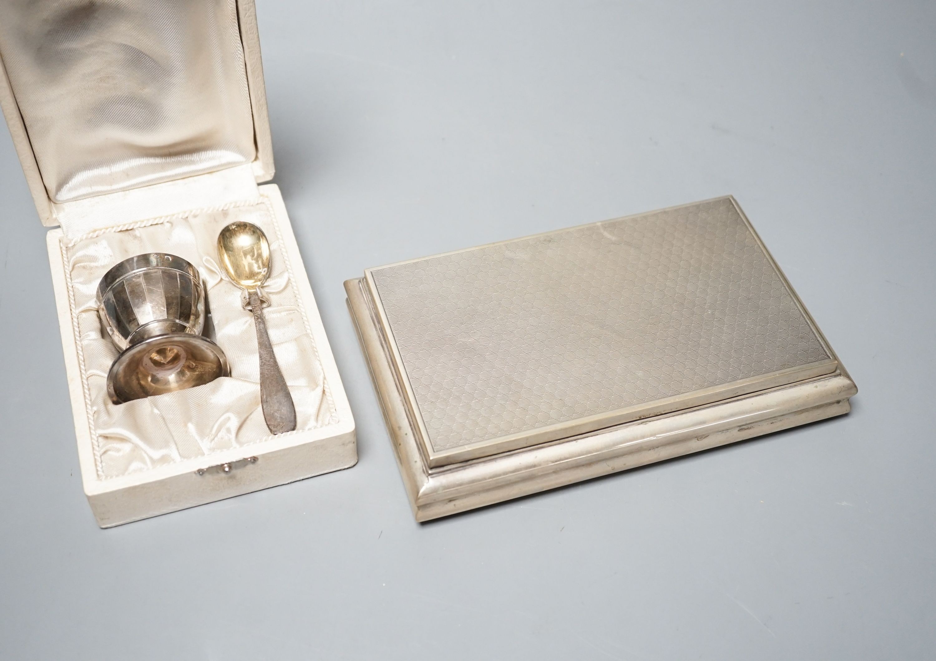 A modern Italian 800 standard white metal mounted cigarette box, 18.5cm and a cased French white metal egg cup and spoon.